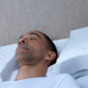 man comfortably sleeping on a contoured white pillow