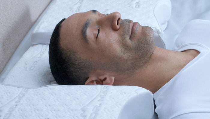 man sleeping on a comfy, white pillow