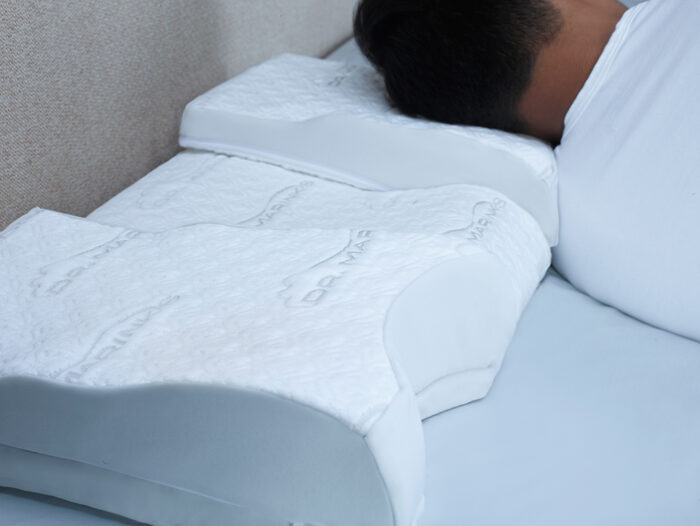 man side sleeping on an elevated part of the white pillow