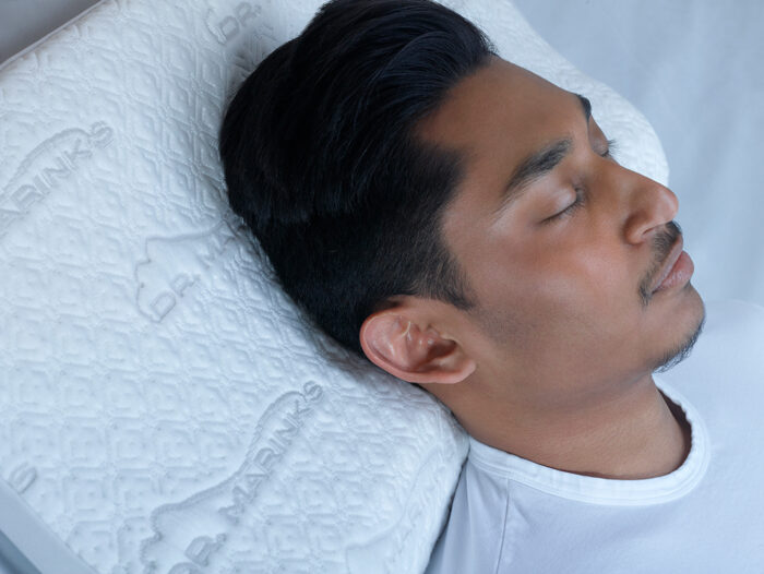 man fast asleep on a white pillow
