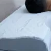 man sleeping on a contoured, white pillow