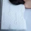 contoured white pillow and a woman fast asleep