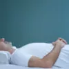 man back-sleeping on a contoured white pillow