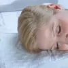 man back-sleeping on a contoured white pillow