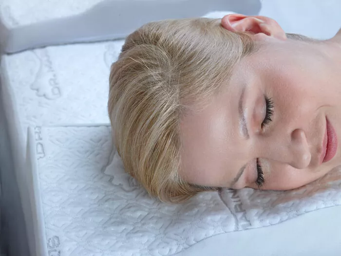 man back-sleeping on a contoured white pillow