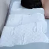 woman side sleeping on the elevated side of a contoured pillow