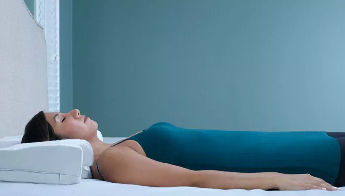 woman back sleeping on a contoured white pillow
